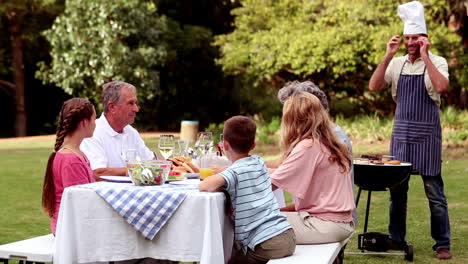 father cooking barbecue for his family