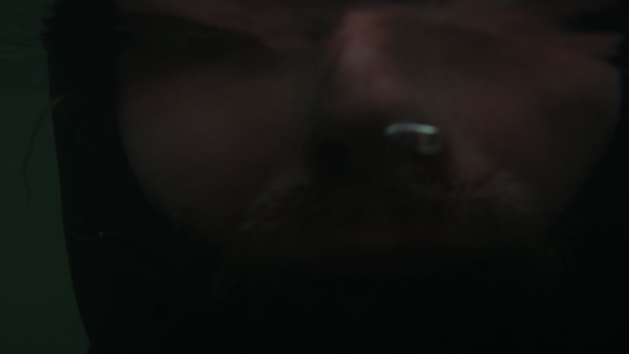 서퍼의 얼굴의 강렬한 클로즈업, 추운 날씨에 대한 탄력성과 집중력을 강조하고, 혹독한 조건에서 겨울 장비와 함께 물 속 느린 동작