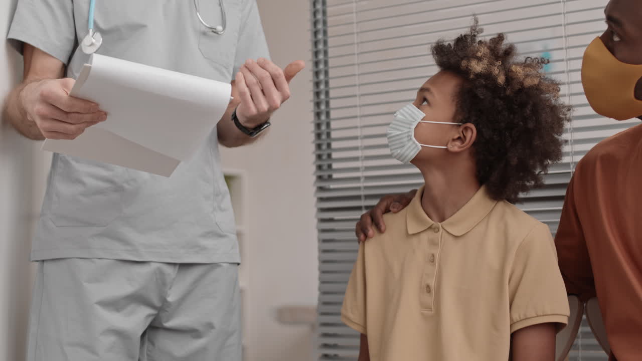 사무실에서 의사를 따라가는 아프리카 소년