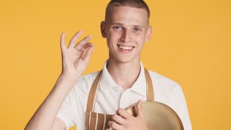 young blond waiter giving ok sign