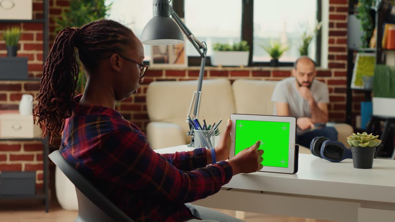Office manager looking at horizontal greenscreen on digital device