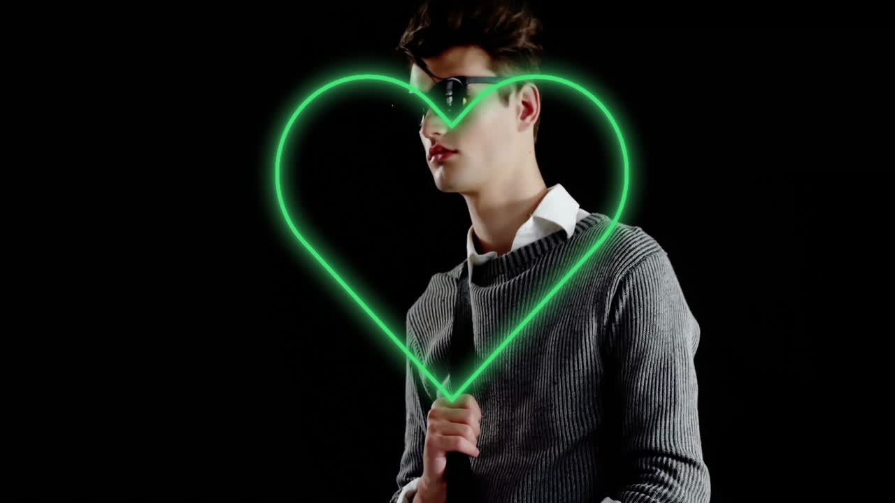 male model posing in studio, highlighting neon green heart using LED wand for technology marketing