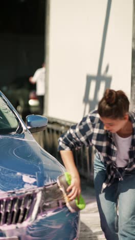mujer lavando un coche azul