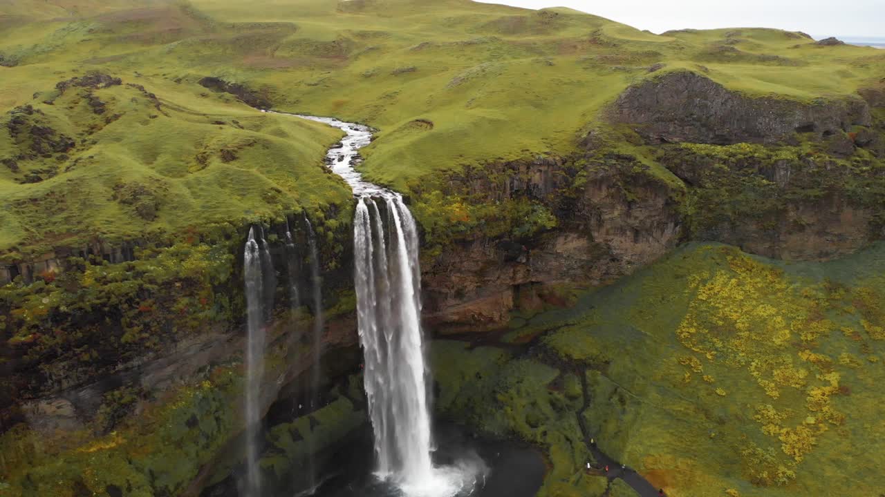 la cascada de seljalandsfoss cae sobre un acantilado rocoso en la piscina de abajo