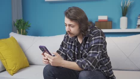the man looking at the phone is confused and disappointed.