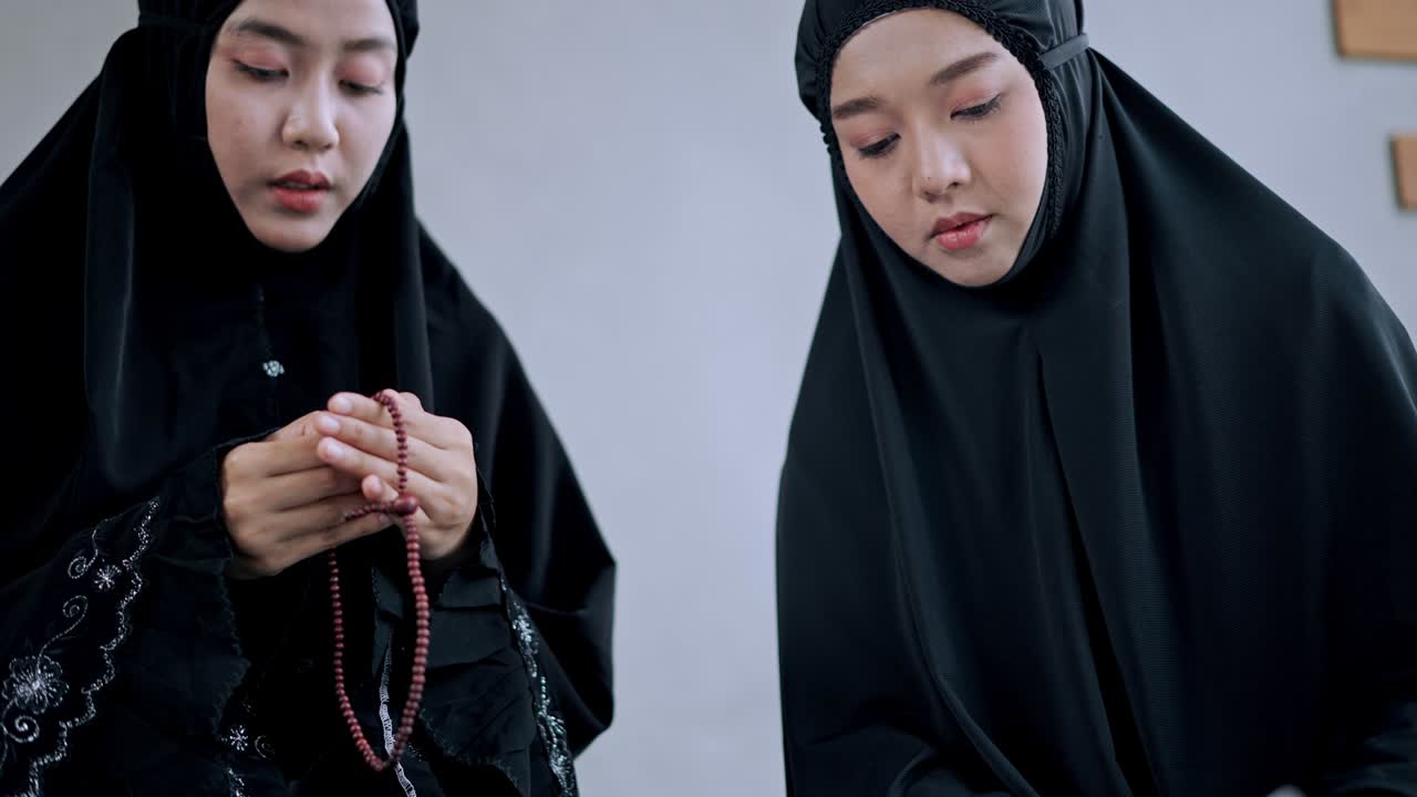 ภาพระยะใกล้ของมือหญิงสาวชาวมุสลิมขณะอ่านคัมภีร์อัลกุรอาน