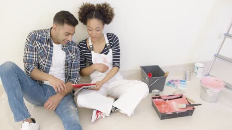 después de un largo día de pintura, una pareja joven se sienta