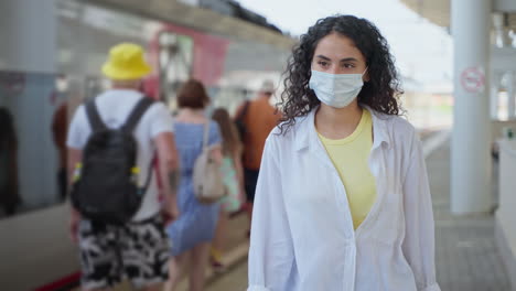 woman wearing a mask at a train station