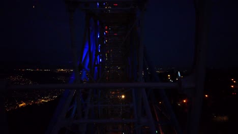 neon night shot of ferris wheel - mtatsmida, tbilisi, georgia.  nightscape, montage, dark amusement park.