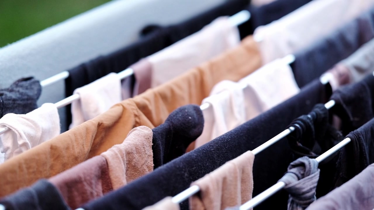 Laundry hanging on a clothes horse outside with grass in the background