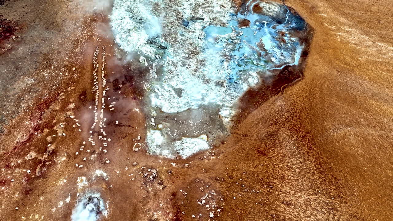 Drone rotating over smoking fumaroles and thermal pools of Hverir, Iceland