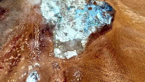 drone rotating over smoking fumaroles and thermal pools of hverir, iceland
