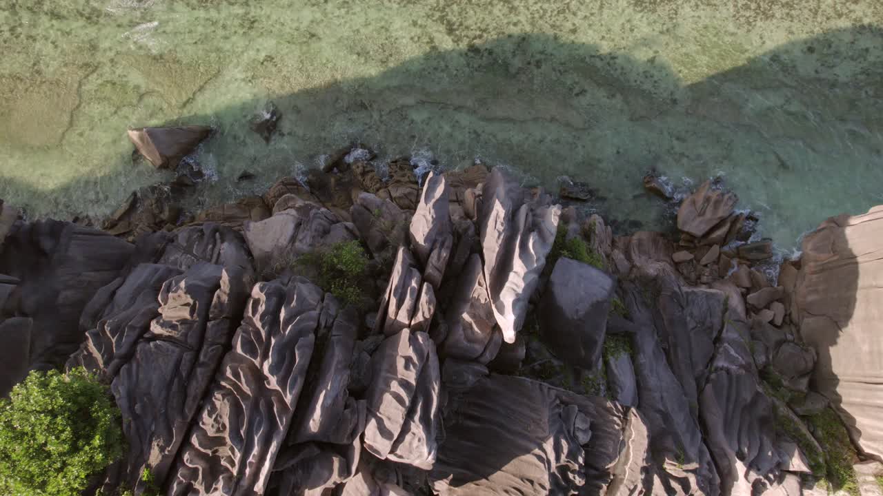 Il filmato del drone cattura i massi di granito frastagliati che costeggiano acque calme e turchesi ad Anse Grosse Roche, La Digue, Seychelles 003 30fps