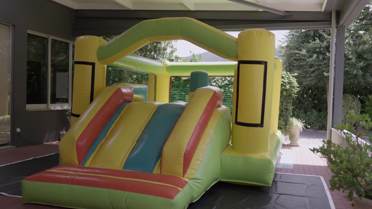 Castillo hinchable inflándose en una terraza cubierta antes de una fiesta infantil