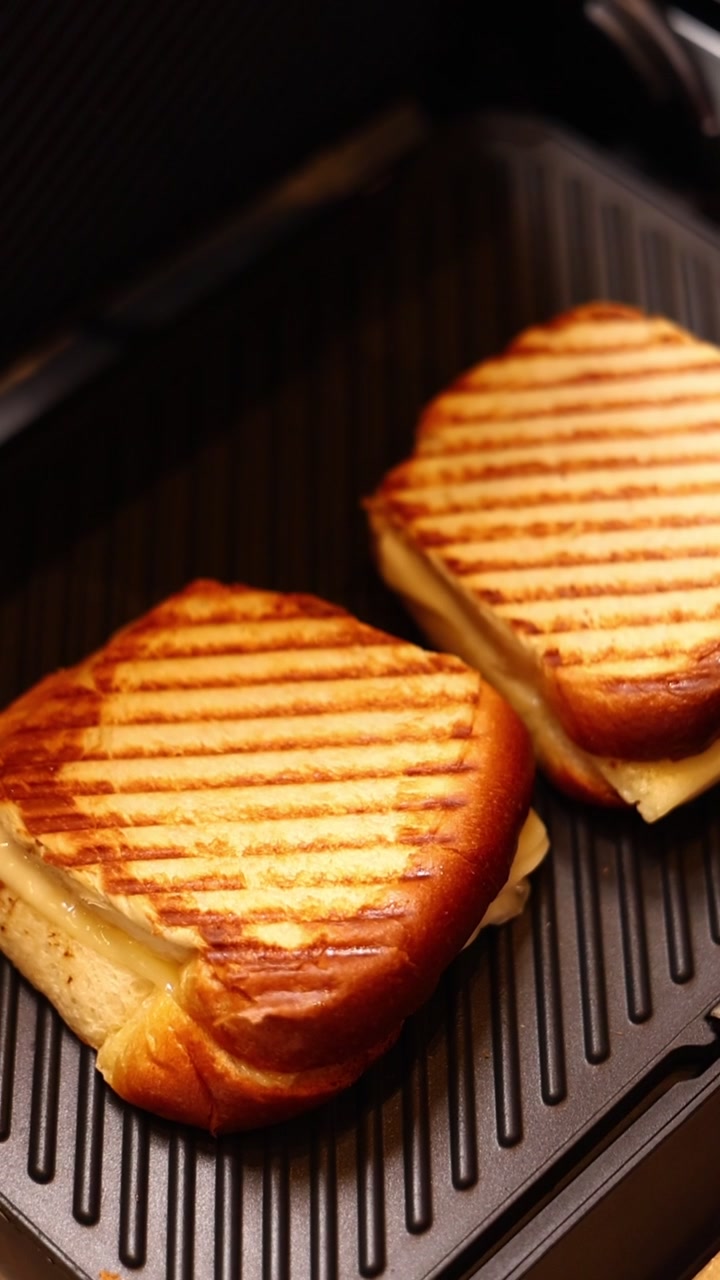 To grillede ostesmørbrød steker på et elektrisk toastjern