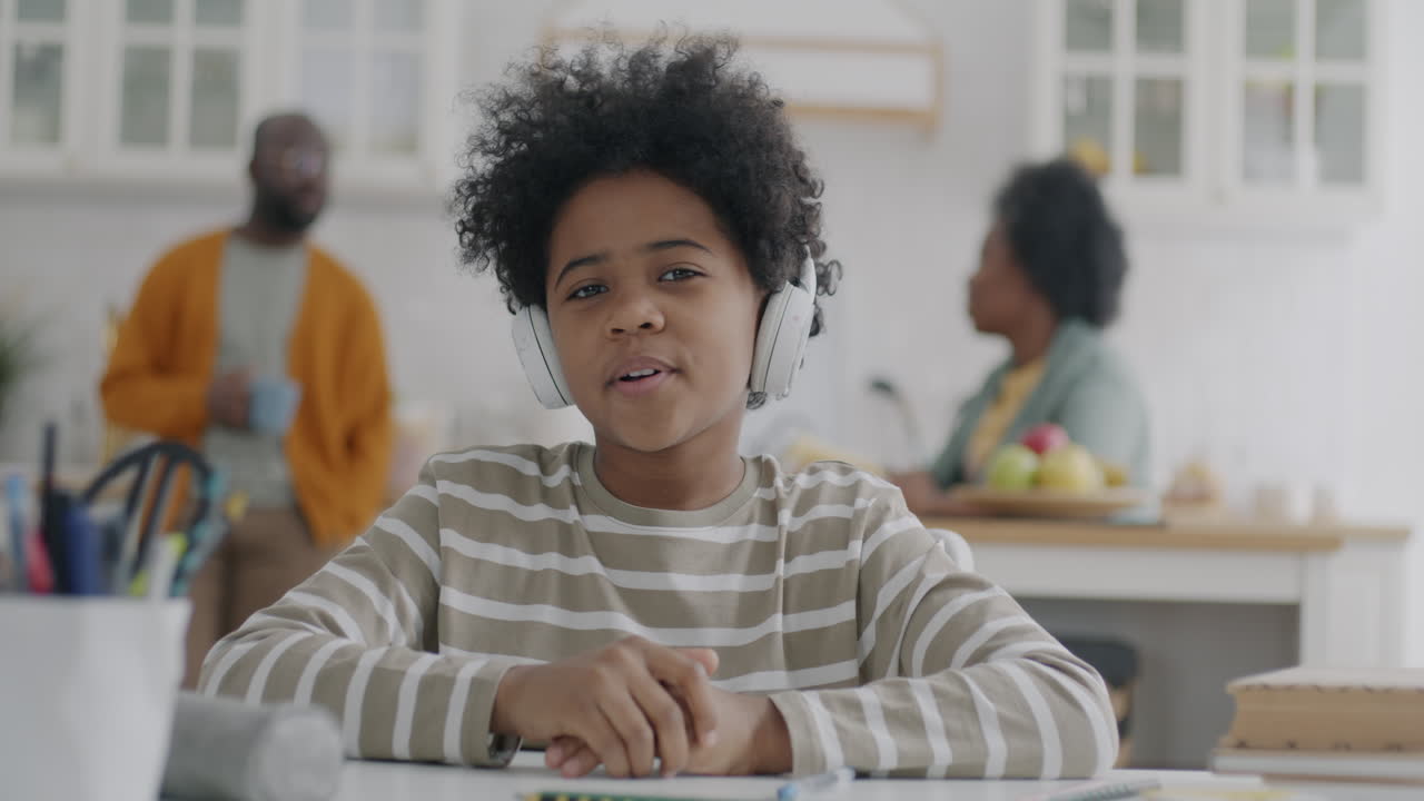 A young boy listening to music while doing homework