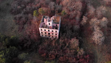 Antiguo-Edificio-De-Fábrica-De-Pólvora-Abandonado-En-El-Bosque-En-Otoño,-Antena-Inclinada-Hacia-Abajo