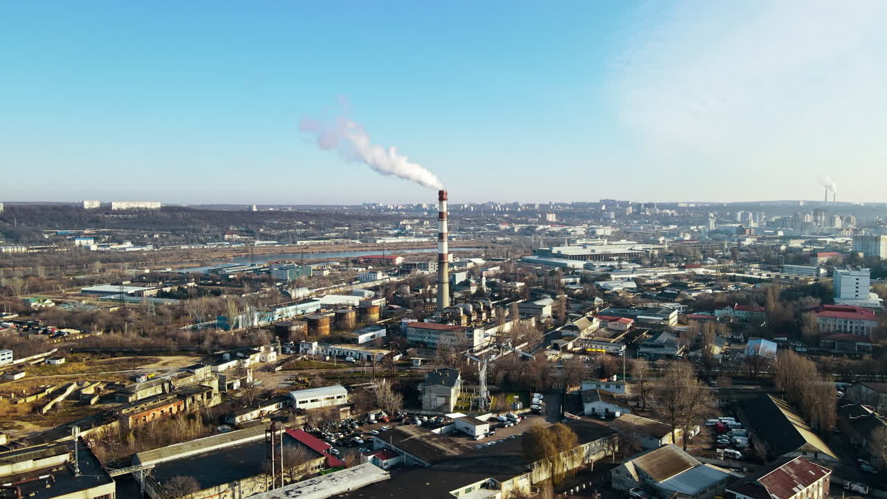 Vista aerea con drone di Chișinău. Centrale termica con fumo che esce dal tubo. Edifici, strade e alberi spogli. Bel tempo. Moldova