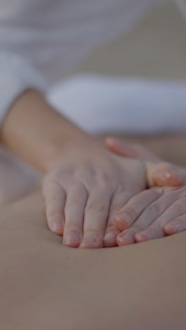 close-up of hands performing a back massage