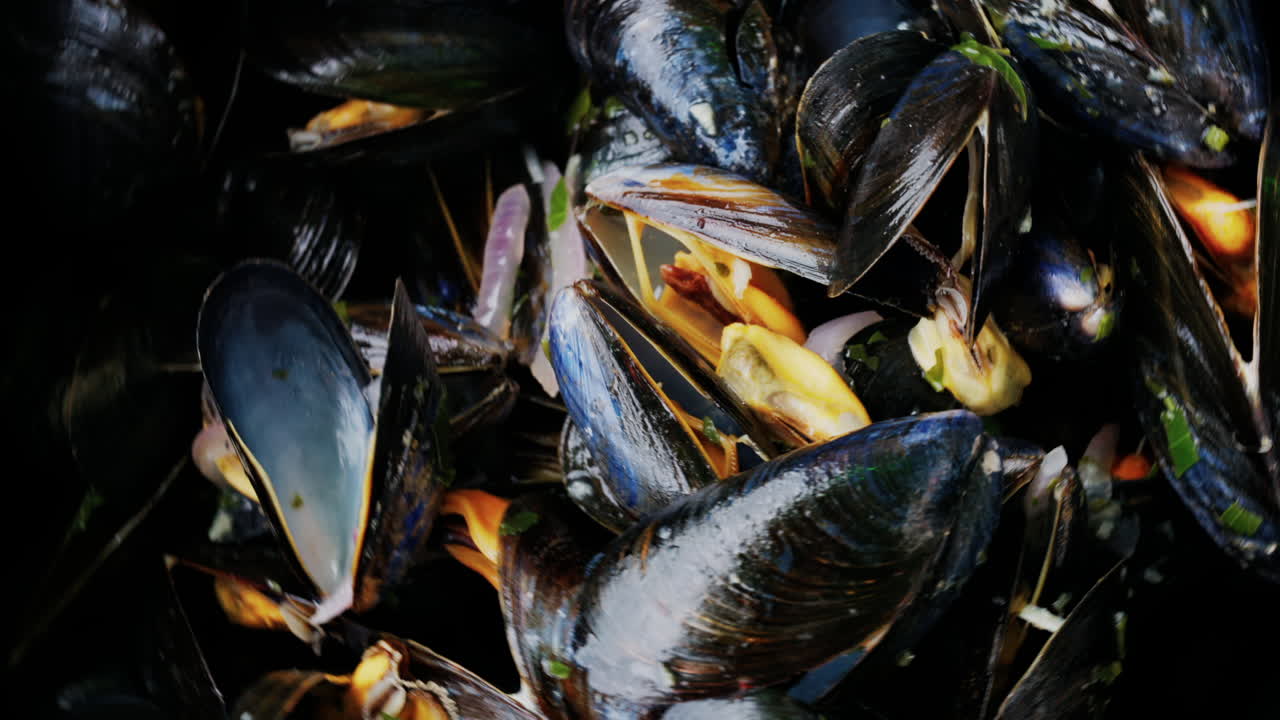 Close up of multiple steamy mussels in a pot