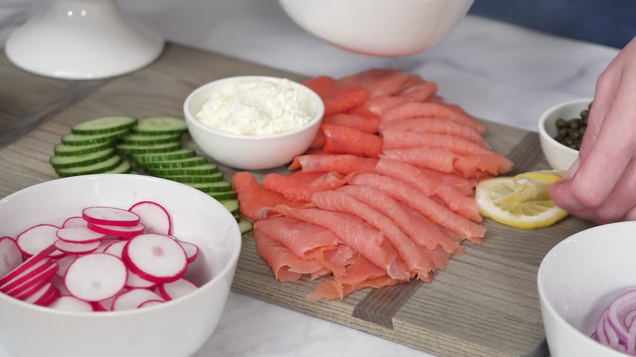 Preparazione di un tagliere per brunch con bagel e salmone affumicato
