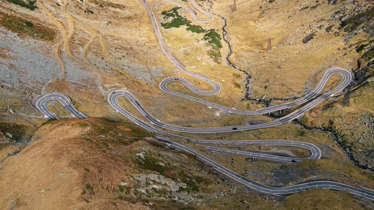 Aerial drone view of nature in Romania. Transfagarasan route with cars in Carpathian mountains, mountains slopes in a valley
