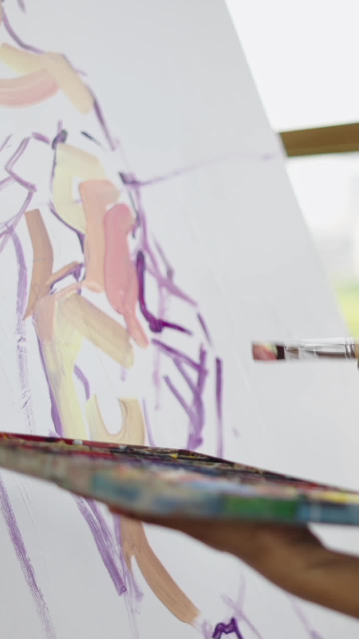 Artist painting an abstract figure on canvas