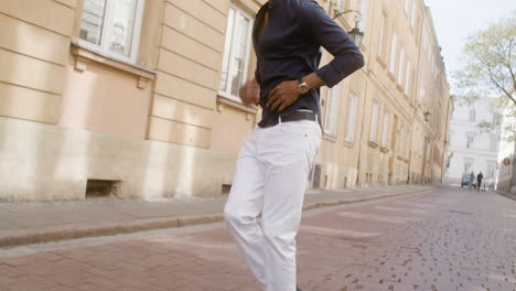 happy afro caribbean man with panama hat dancing latin dance alone in the old town street 2