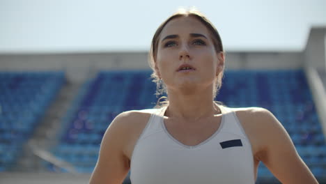 a time lapse portrait of beautiful woman running on the stadium bleachers with concentrated deep breathing and motivating myself and consciousness for the race. discard unnecessary emotions and tune in to win preparing for the race