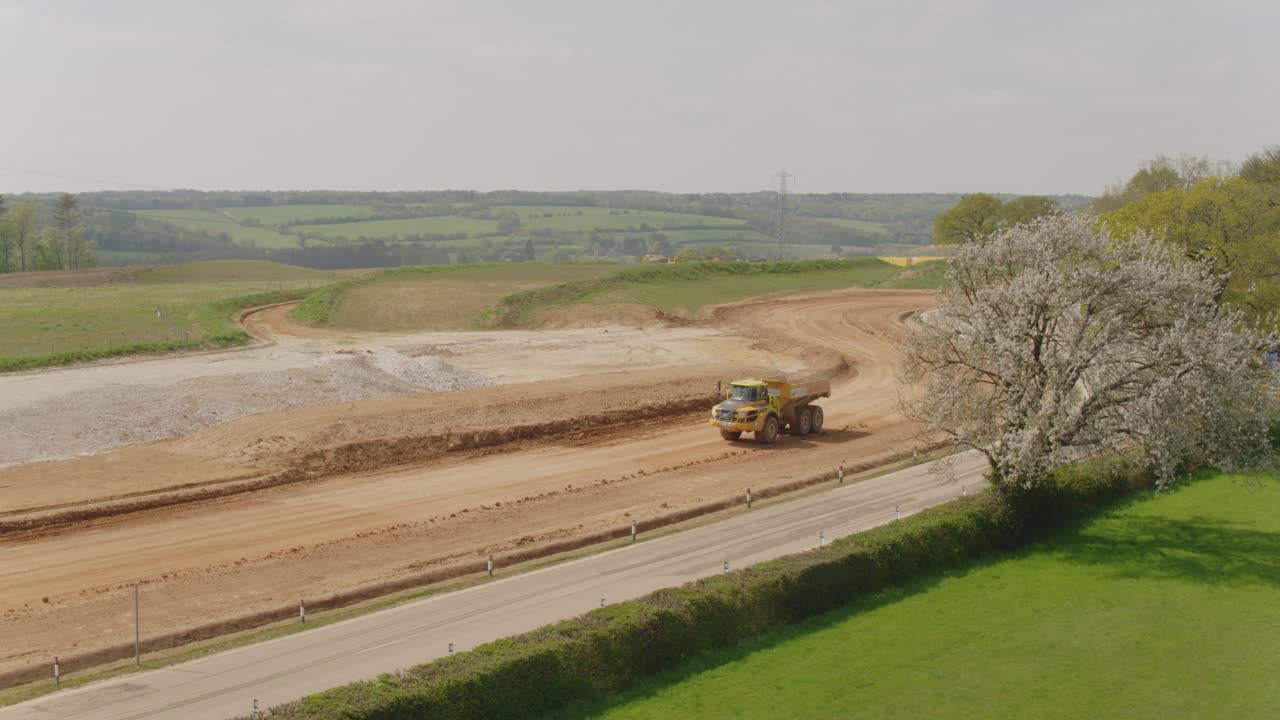 A dump truck makes its way at speed along a construction site track