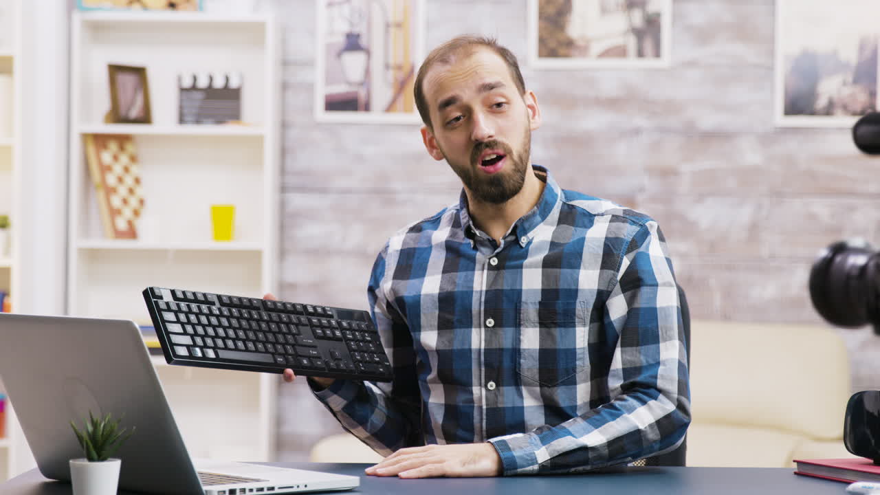 Man holding keyboard in front of camera