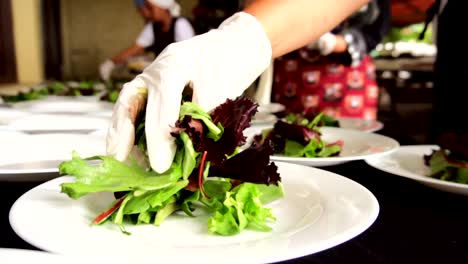 hands putting leaves for salad at a banquet