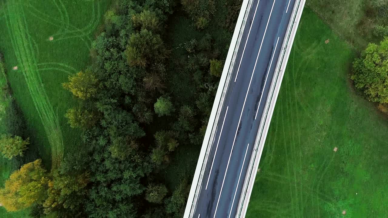 воздушный вид на шоссе во франции. только травяные поля и деревья вокруг дорог. автомобили и грузовики ездят по дорогам под солнцем.