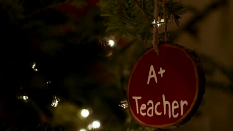 Close-Up-Great-Teacher-Decoration-Hanging-on-a-Real-Fir-Christmas-Tree