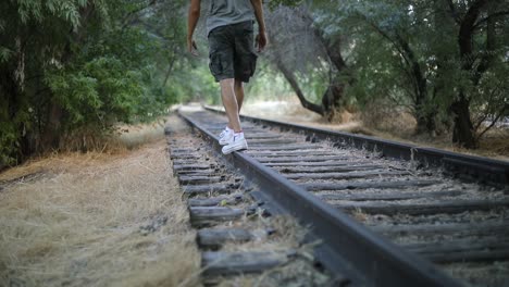 Toma-En-Cámara-Lenta-De-Alguien-Caminando-Sobre-Vías-De-Tren-Abandonadas