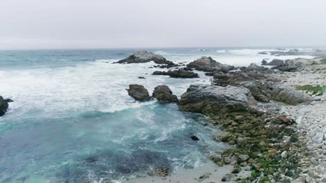 Rocky-Monterey-California-Beach-with-waves-crashing-and-birds-flying-in-slow-motion-aerial-view