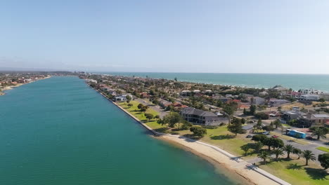 Aerial-shot-above-the-picturesque-West-Lakes-in-Tennyson,-Adelaide,-South-Australia,-looking-out-towards-the-ocean-and-coastline