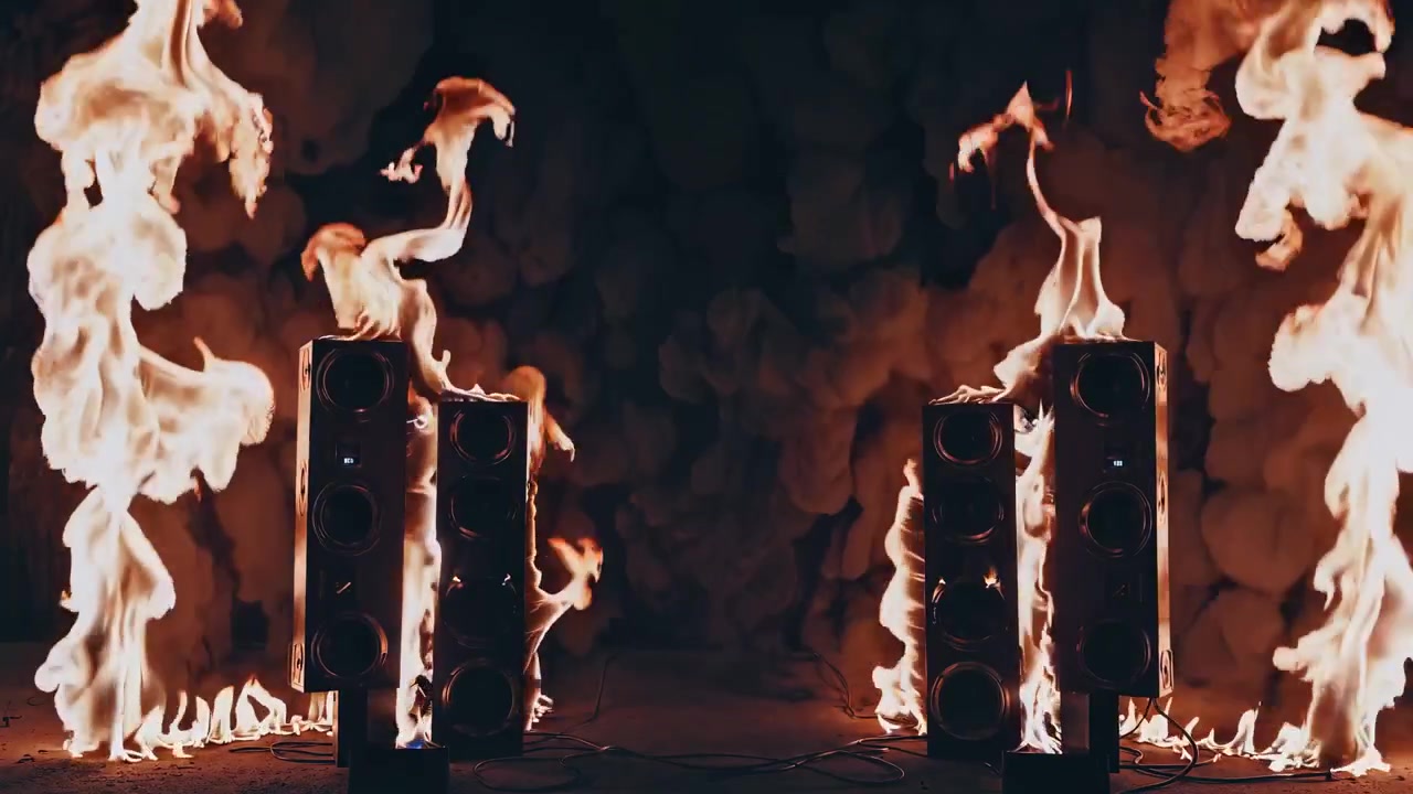 Two Tall Speakers Surrounded by Intense Flames in Dark Studio