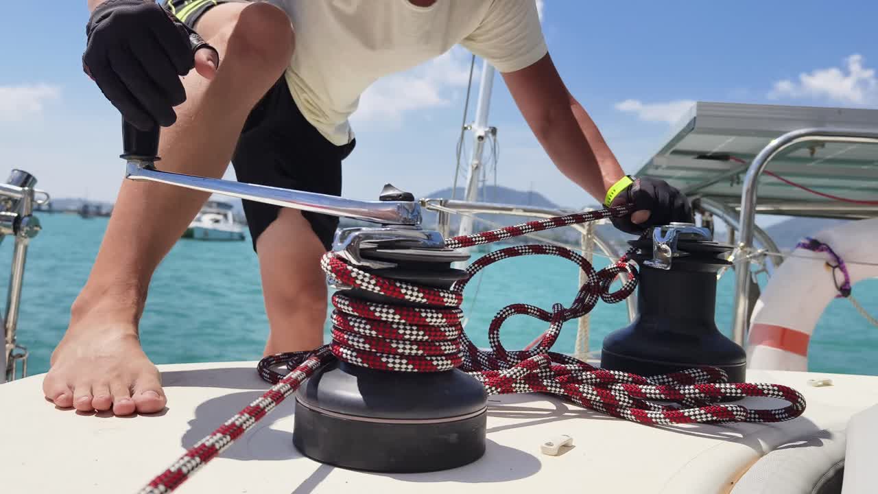Sailor operating a winch on a sailboat