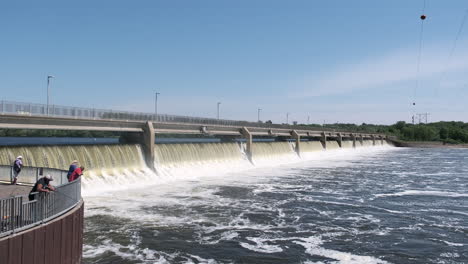 people fishing in front of a hydroelectric dam