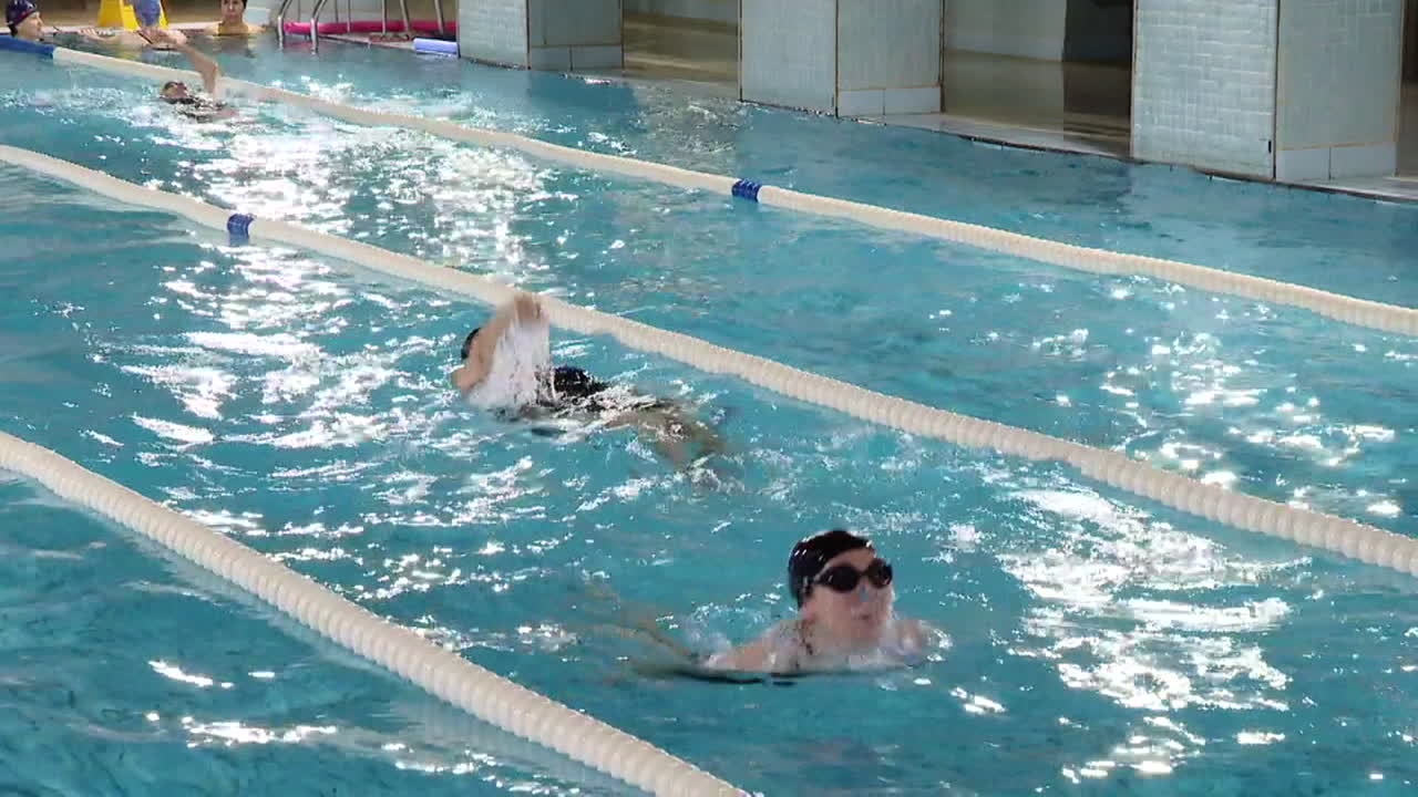 personas nadando en una piscina