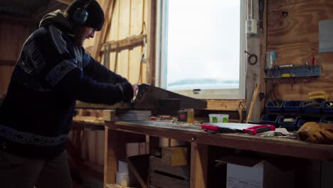 a man is using a saw to cut lumber manually - static shot