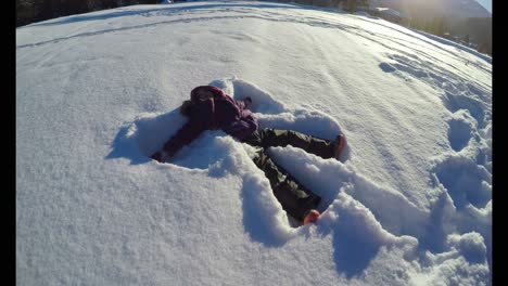 kid making snow angels in snow during winter 4k