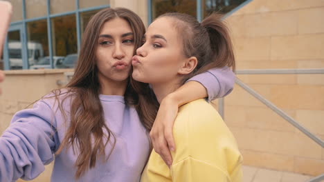 young female friends taking a selfie outside