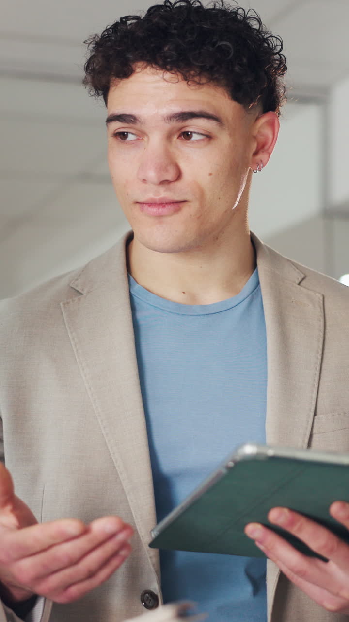 Young Man Explaining and Gesturing While Holding a Tablet
