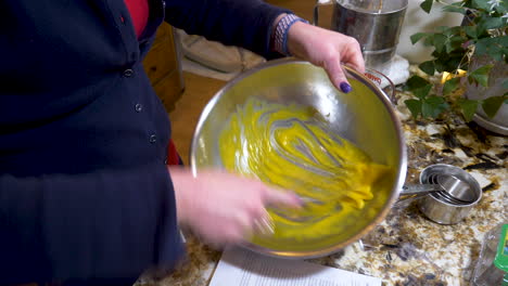 skilled woman hand whisking egg yolks - close up