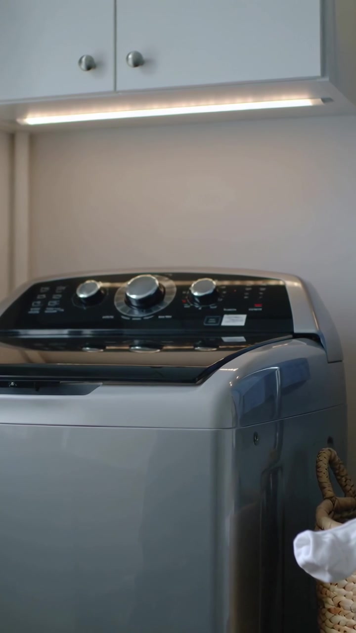Verticale video: Wasmachine sluiten, deksel laten zakken over het bedieningspaneel in een washoekje, was starten.