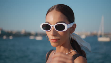 woman wearing stylish sunglasses by the ocean