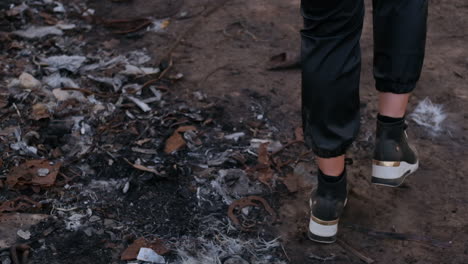 close-up of woman with sneakers walking a dumpsite