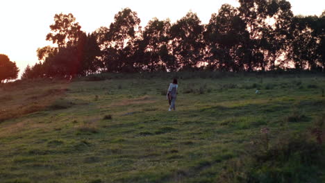 Silueta-De-Una-Mujer-Joven-Caminando-Hacia-El-Bosque-En-La-Hora-Dorada